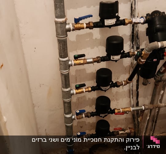 צינורות מים עם ברזים ומדי מים בחדר שירותים